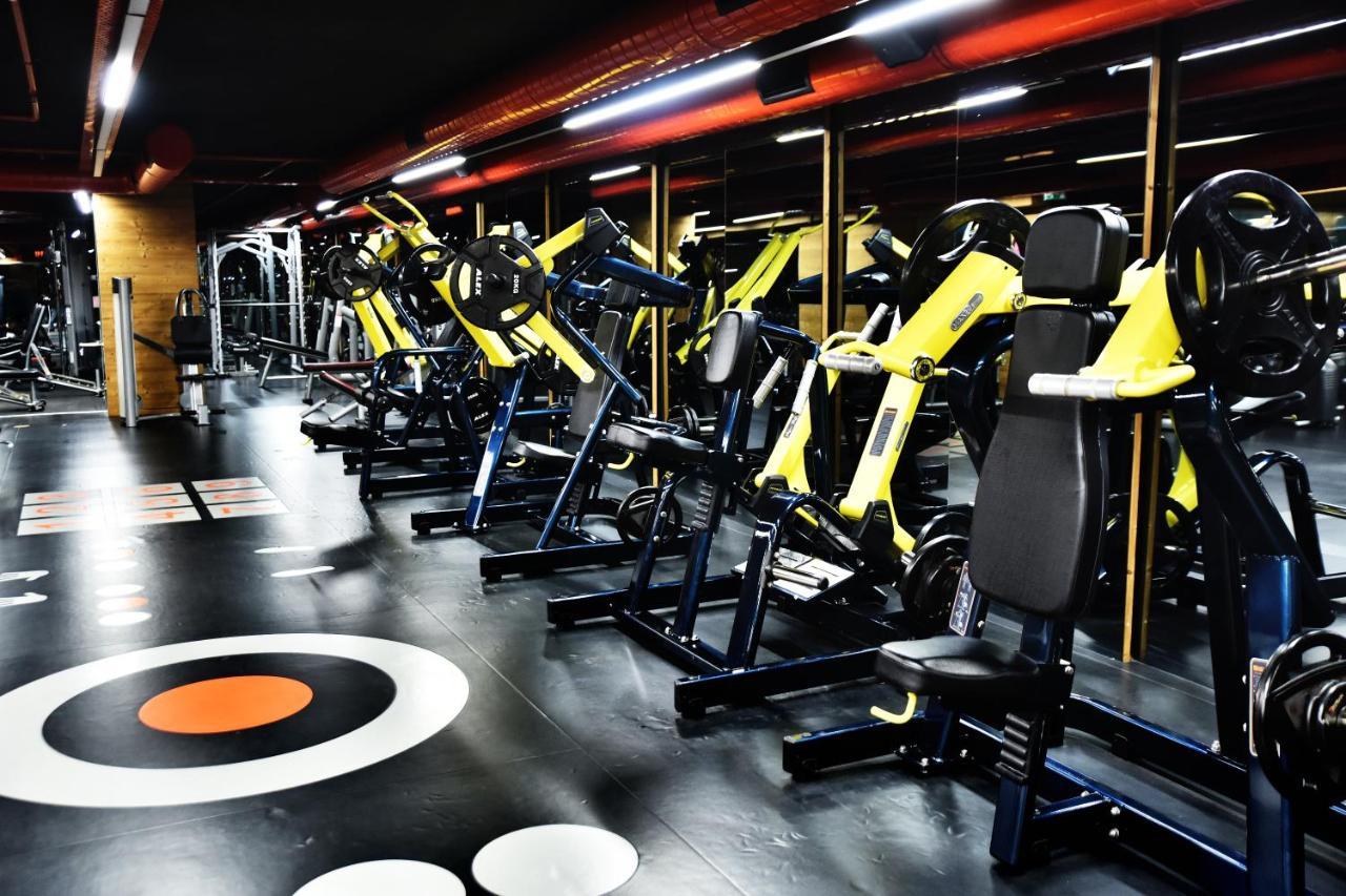 Dosso Dossi Hotels & Spa Downtown Istanbul Exterior photo The photo shows a modern gym interior featuring various exercise machines. There are several yellow and black weight training machines aligned in rows, with a focus on strength training equipment. The flooring is dark with circular patterns, includin