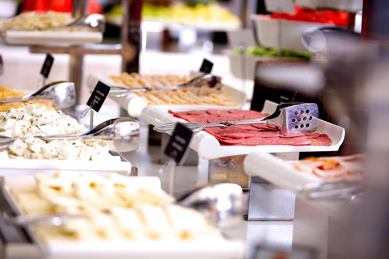 Dosso Dossi Hotels & Spa Downtown Istanbul Exterior photo The image displays a buffet setting with various food items arranged on tables. There are multiple white serving trays filled with different types of food, including sliced meats, spreads, and possibly salads or other accompaniments. Each tray has a 
