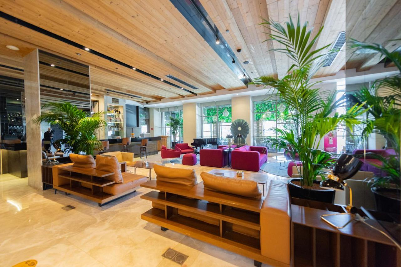 Dosso Dossi Hotels & Spa Downtown Istanbul Exterior photo The photo shows a modern interior of a lobby or lounge area. It features wooden ceilings and a mix of natural and contemporary design elements. There are several comfortable seating arrangements, including plush sofas in various colors such as beige 