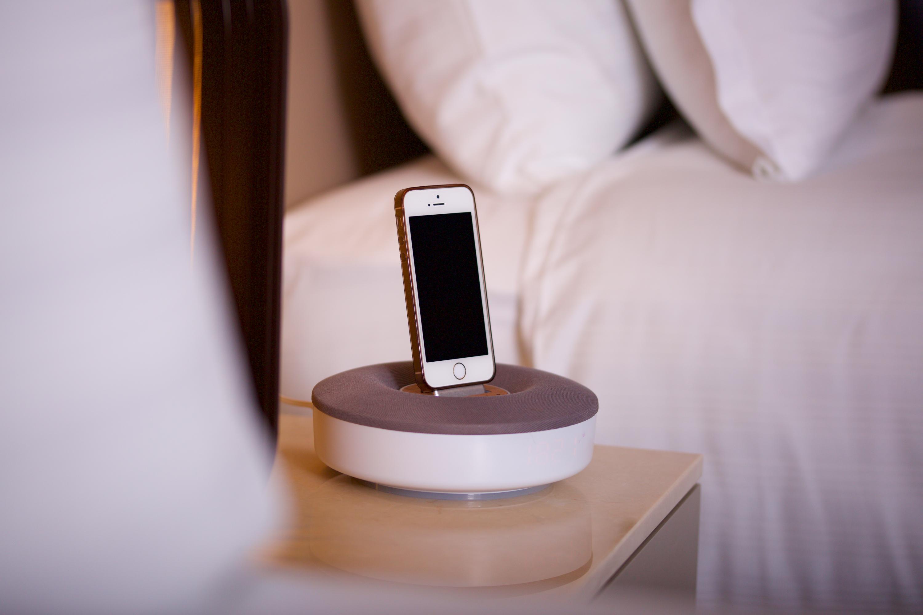 Dosso Dossi Hotels & Spa Downtown Istanbul Exterior photo The photo shows a smartphone placed on a charging dock. The dock has a circular base with a gray top and a white bottom. The smartphone is upright in the dock, facing forward, and has a blank screen. There are neatly arranged pillows visible in the b