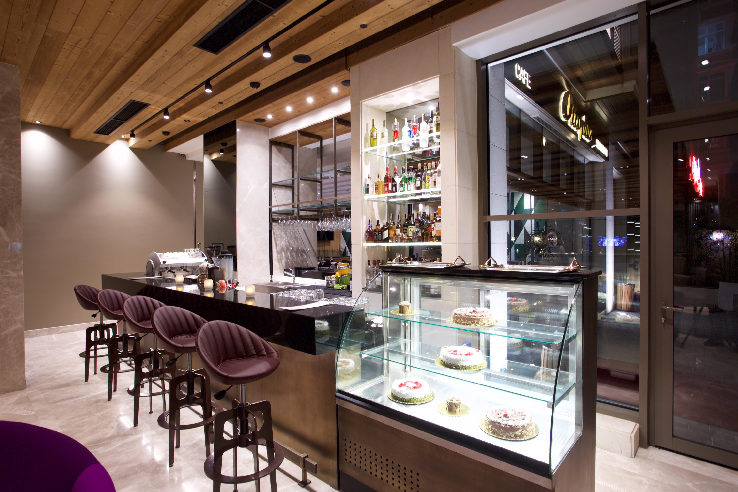 Dosso Dossi Hotels & Spa Downtown Istanbul Exterior photo The photo shows the interior of a modern restaurant or café. There is a sleek bar area with a few high stools and a polished countertop. Behind the bar, shelves are stocked with various bottles, indicating a selection of drinks. To the right, there's