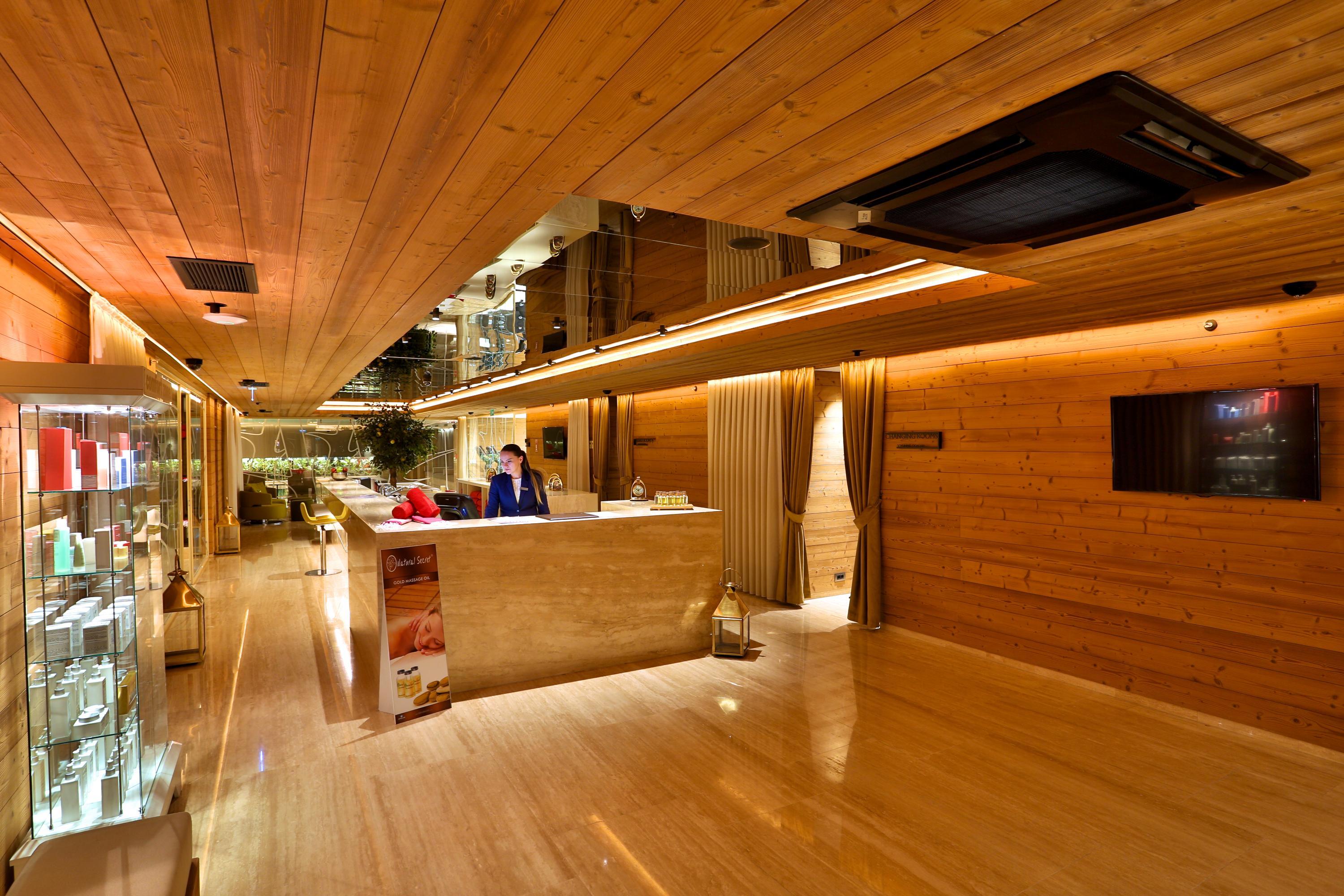 Dosso Dossi Hotels & Spa Downtown Istanbul Exterior photo The photo depicts a modern reception area or lobby with a warm and inviting design. The walls and ceiling are finished in wood, creating a cozy atmosphere. There is a polished stone or marble floor that reflects light, enhancing the brightness of the