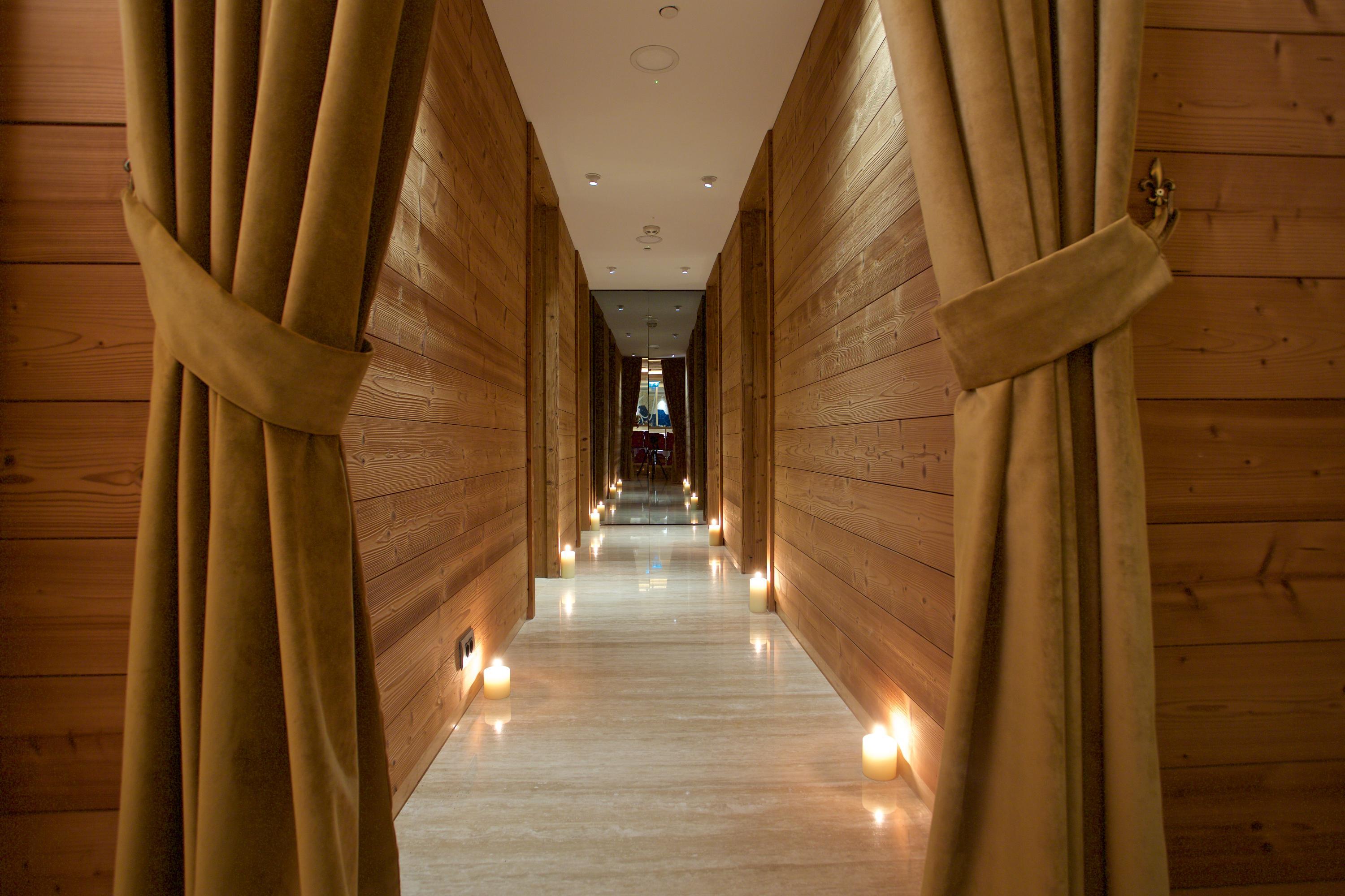 Dosso Dossi Hotels & Spa Downtown Istanbul Exterior photo The photo shows a serene hallway with a modern aesthetic. The walls are made of wood, giving a warm and inviting feel. At the sides of the hallway, there are soft, draped curtains that add a touch of elegance. The floor is well-lit, primarily featuri