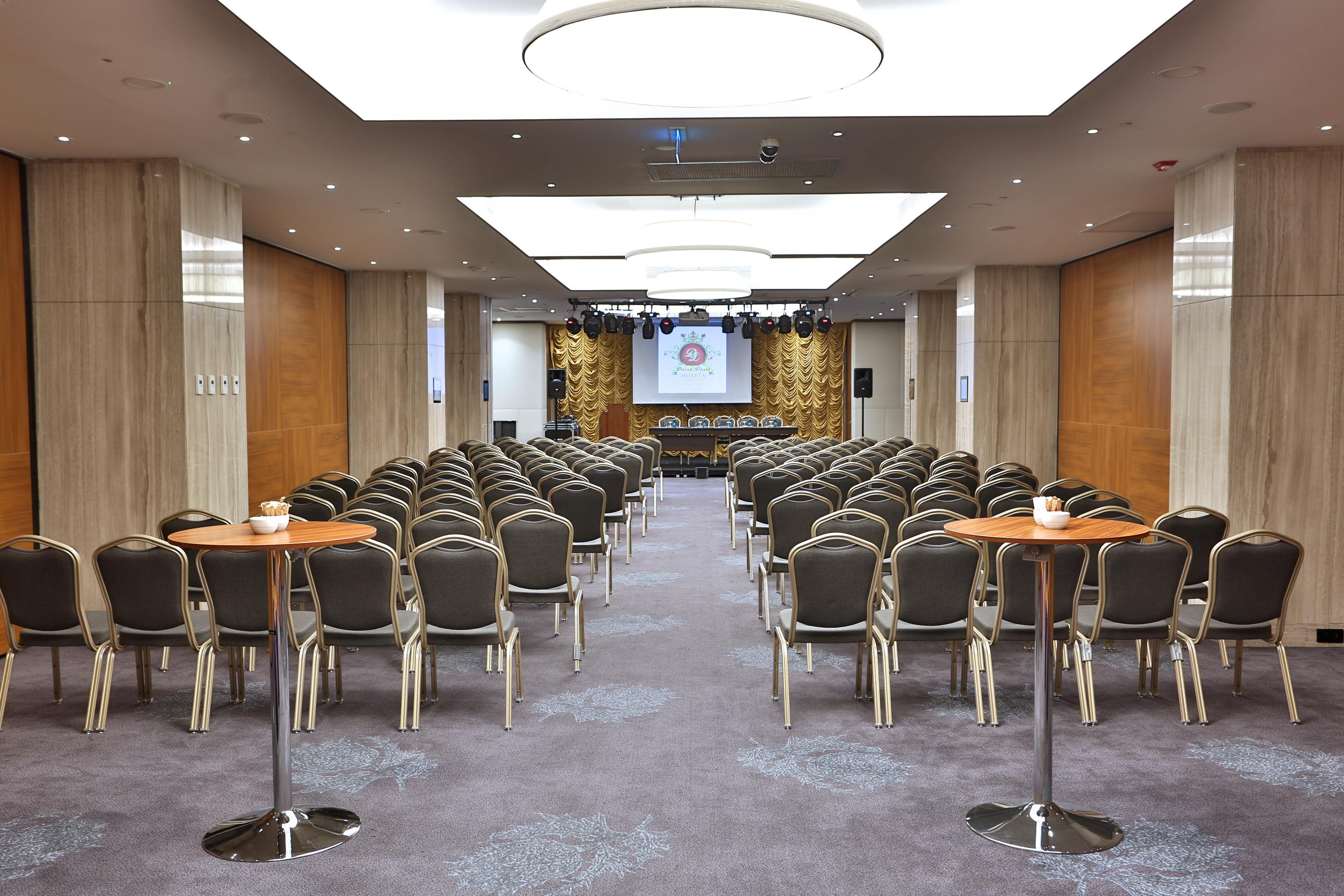 Dosso Dossi Hotels & Spa Downtown Istanbul Exterior photo The photo shows a spacious meeting or conference room. There are many rows of chairs arranged in a theater-style setup, indicating that it's likely meant for presentations or lectures. In the front of the room, there is a stage or platform area with 