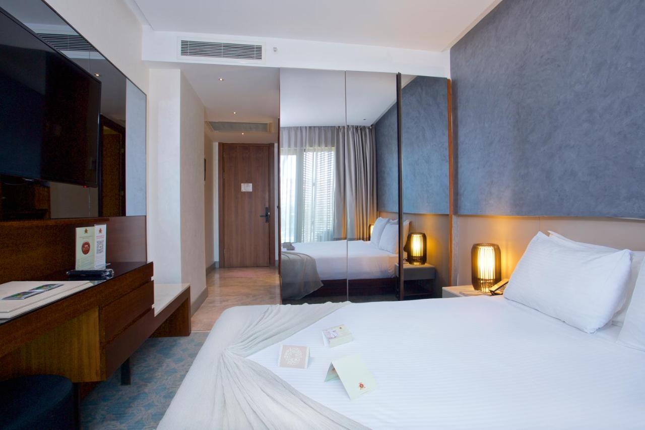 Dosso Dossi Hotels & Spa Downtown Istanbul Exterior photo The photo shows a modern hotel room. It features a neatly made bed with white linens, and there are decorative items placed on the bed. The room has a contemporary design with light-colored walls and a large window allowing natural light to enter. 

